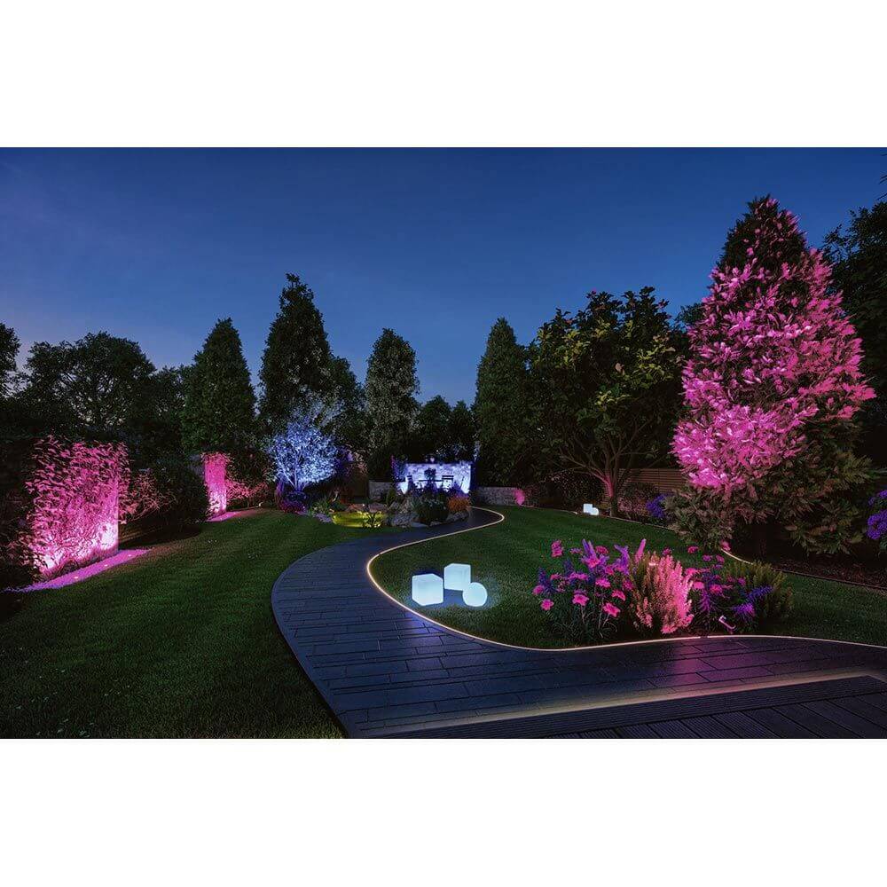 Beleuchteter Garten mit Plug & Shine LED Strip und bunten Akzenten in lila und pink, sanfte Lichtlinie.
