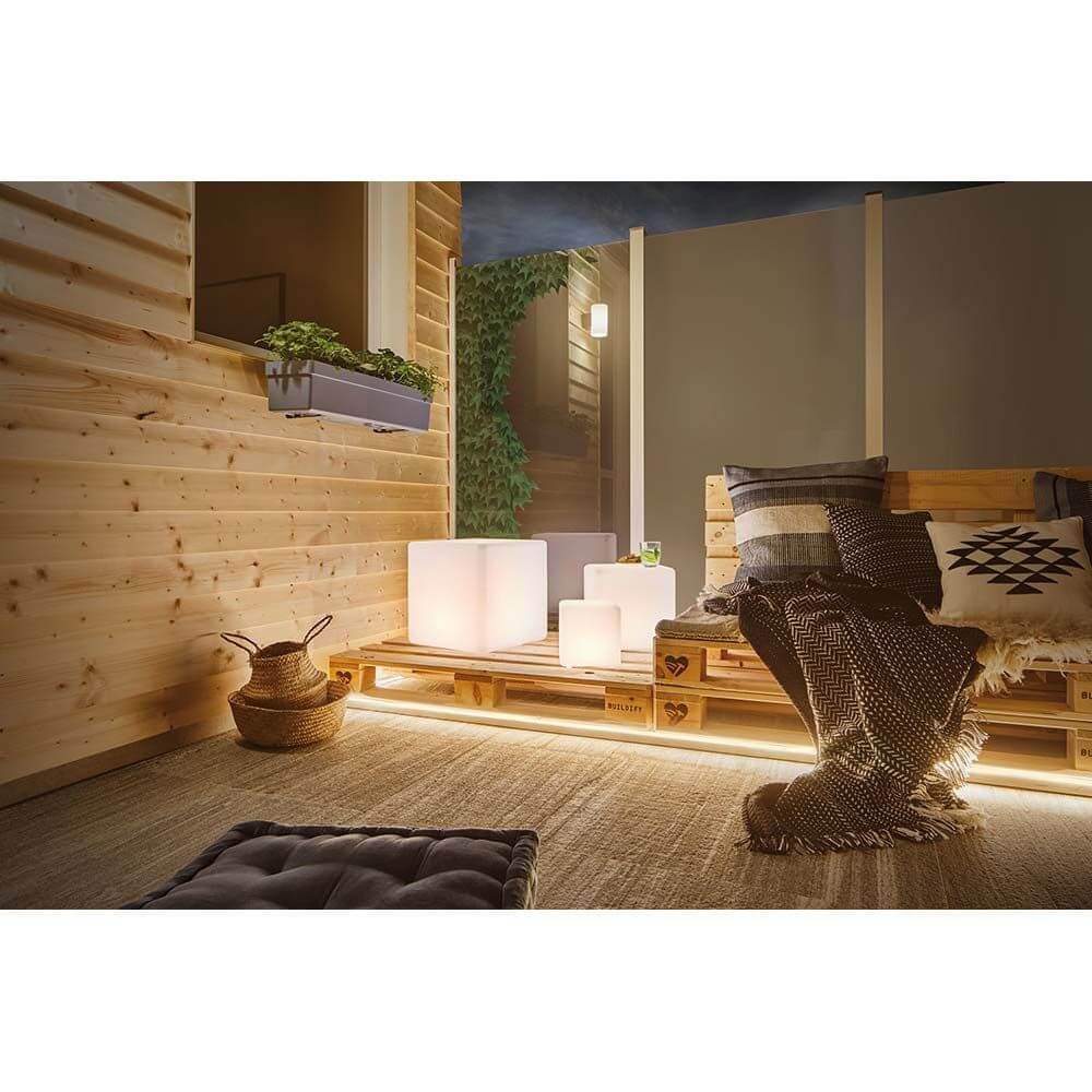 LED Plug & Shine Neon Stripe IP67 3000K 5m beleuchtet gemütliche Außenlounge mit Holzpaletten und modernen Akzenten.