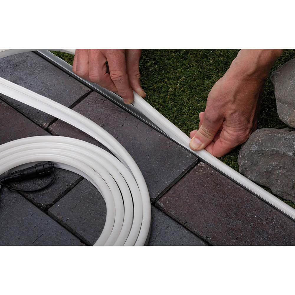 Anbringen des Plug & Shine Neon-Stripe Profils 1m auf einer Gartenfläche mit LED Strip.