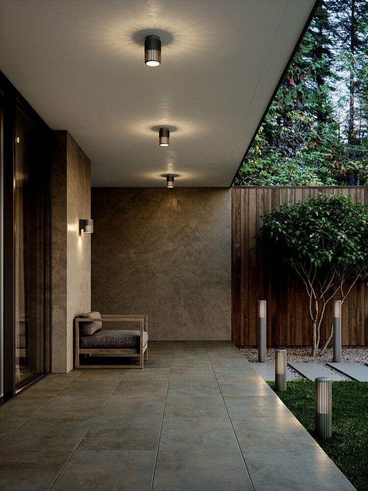 Pollerleuchte Aludra 45 IP54 auf modernem Gartenweg mit altem Baum und stilvollem Sitzbereich.
