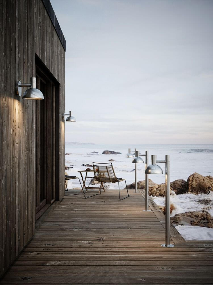 Pollerleuchte Arki 100 IP54 auf einer Terrasse am Meer, beleuchtet den Außenbereich mit eleganter Schlichtheit.