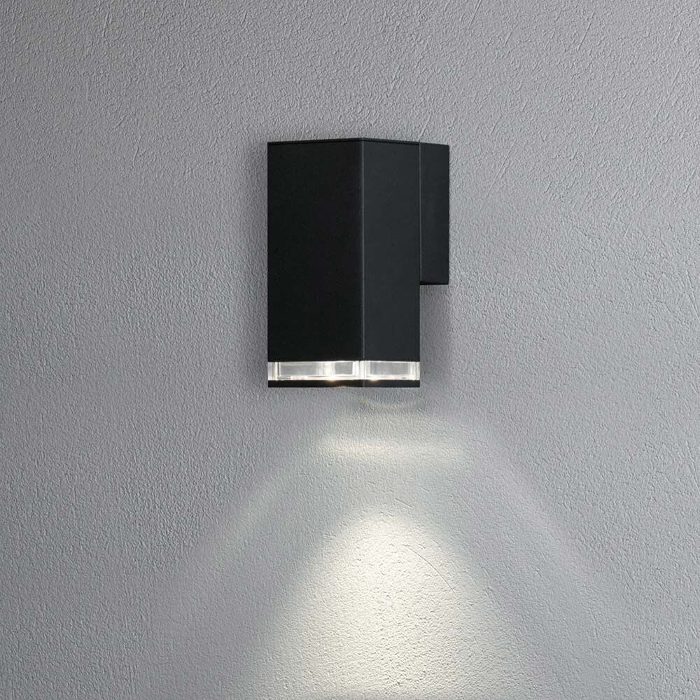 Pollux Außen Wandleuchte IP44 in Schwarz an einer Wand montiert, beleuchtet den Raum.