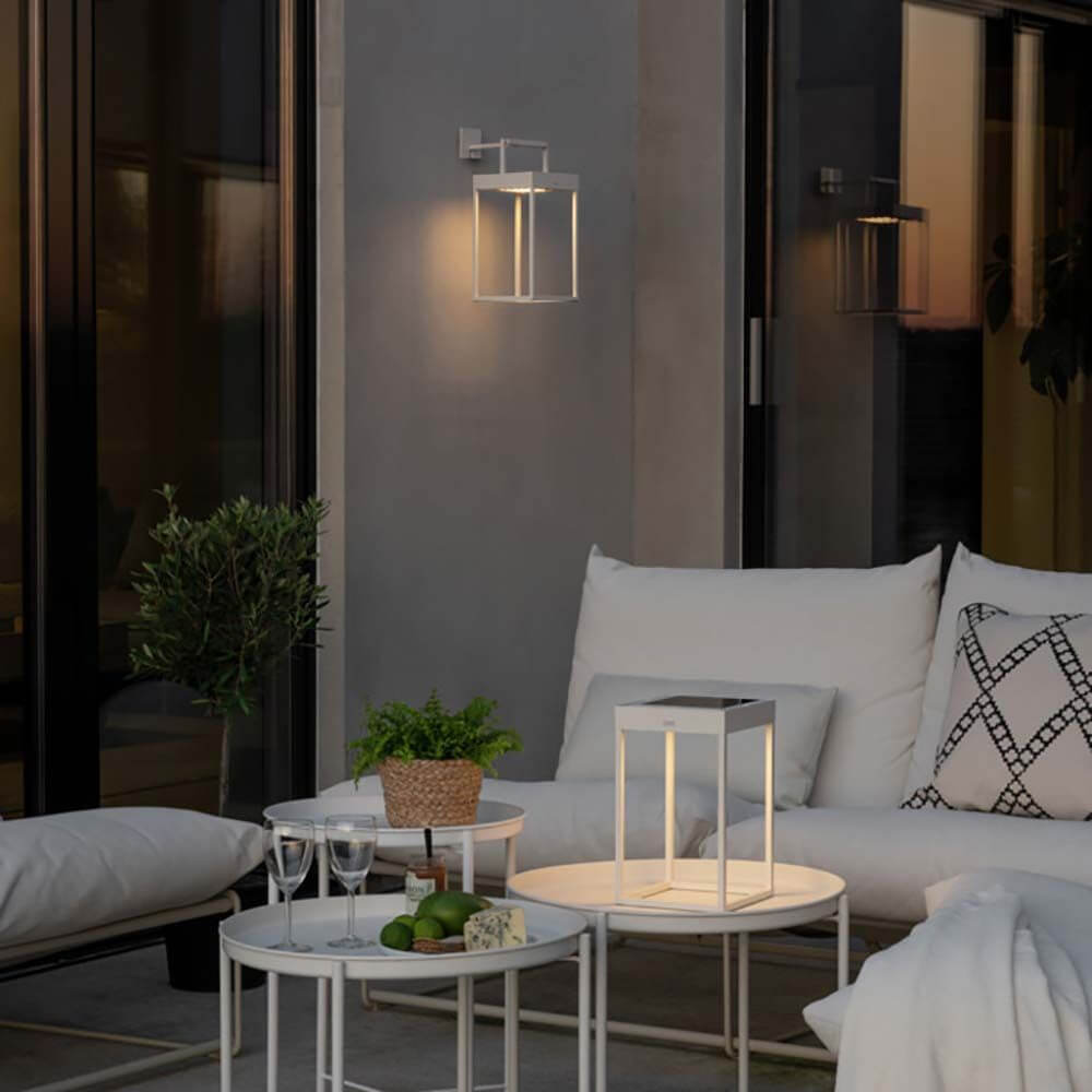 Portofino LED Solar Bodenleuchte IP54 in einem modernen Außenbereich mit gemütlichen Sitzgelegenheiten.