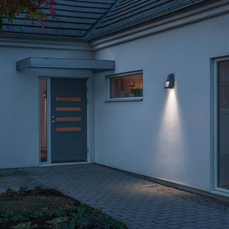 Potenza outdoor wall lamp anthracite IP54 on a house wall with warm light.