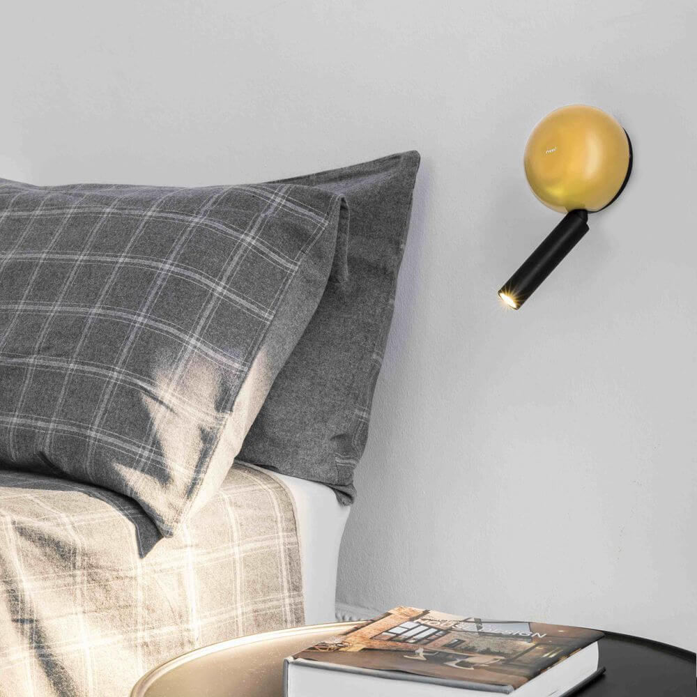 Press LED Wand-Leselampe an der Wand über einem Bett mit Kissen und Nachttisch.
