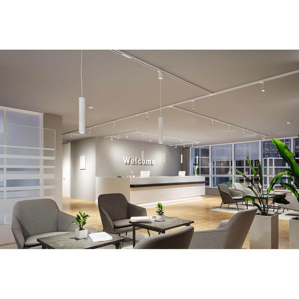 Moderne Lobby mit ProRail3 Pendelleuchte Artemons in Weiß über Empfangstresen und gemütlichen Sitzbereichen.