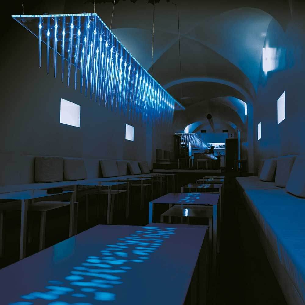 Moderne Bluegrass Design-Pendelleuchte in einem stilvollen Raum mit blauer Beleuchtung.