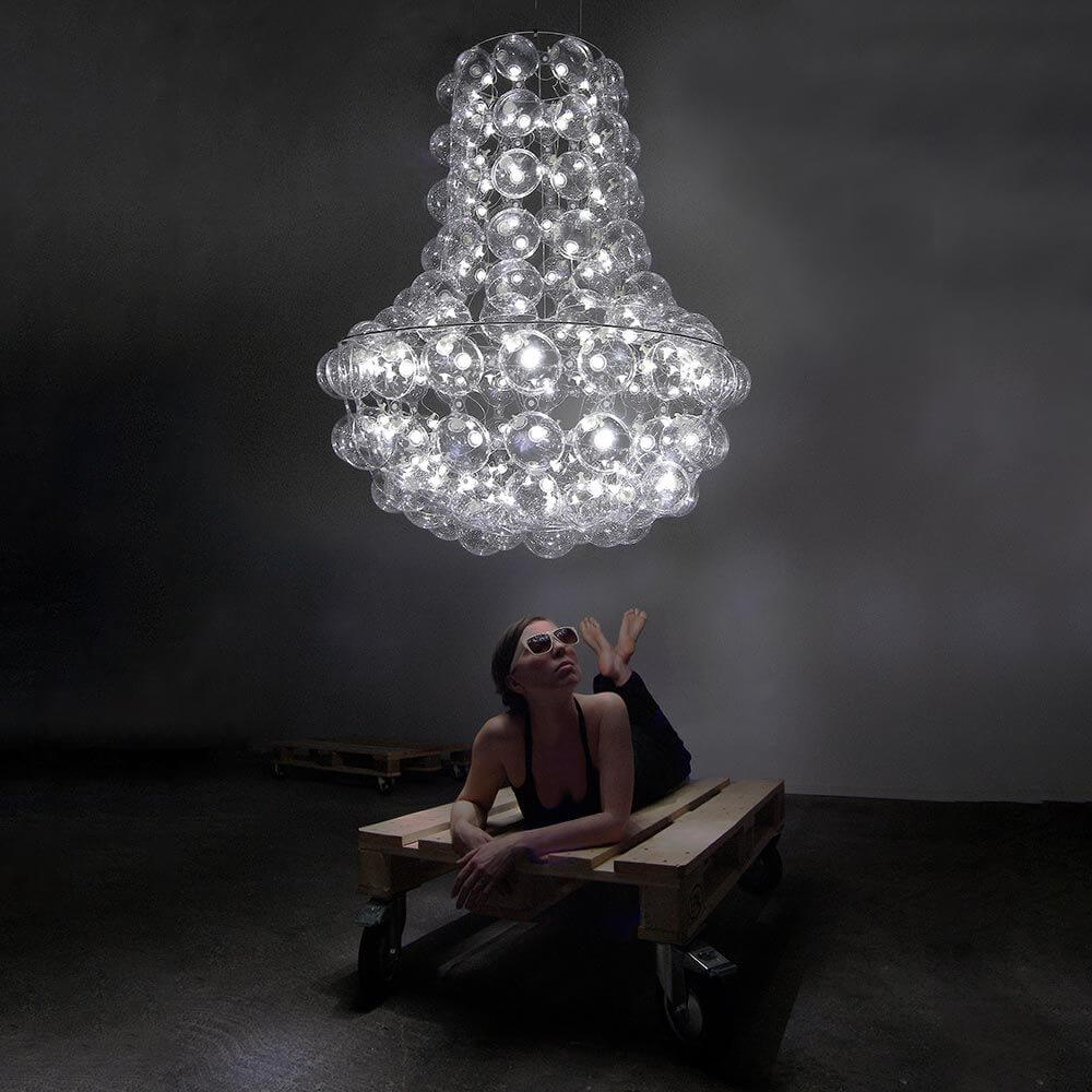 Kronleuchter Queen's Design mit 145 luftgefüllten Bubbles und LED-Beleuchtung, schwebend über einer liegenden Person.