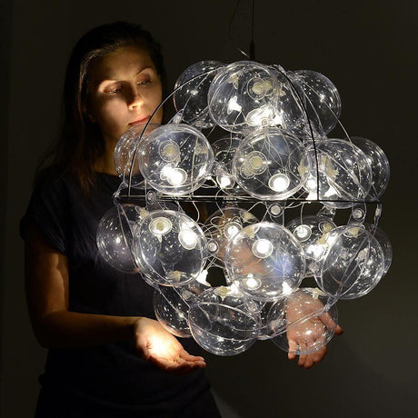 Starlette Design-Pendelleuchte 50cm in modernem Stil, präsentiert von einer Person in einem stilvollen Raum.