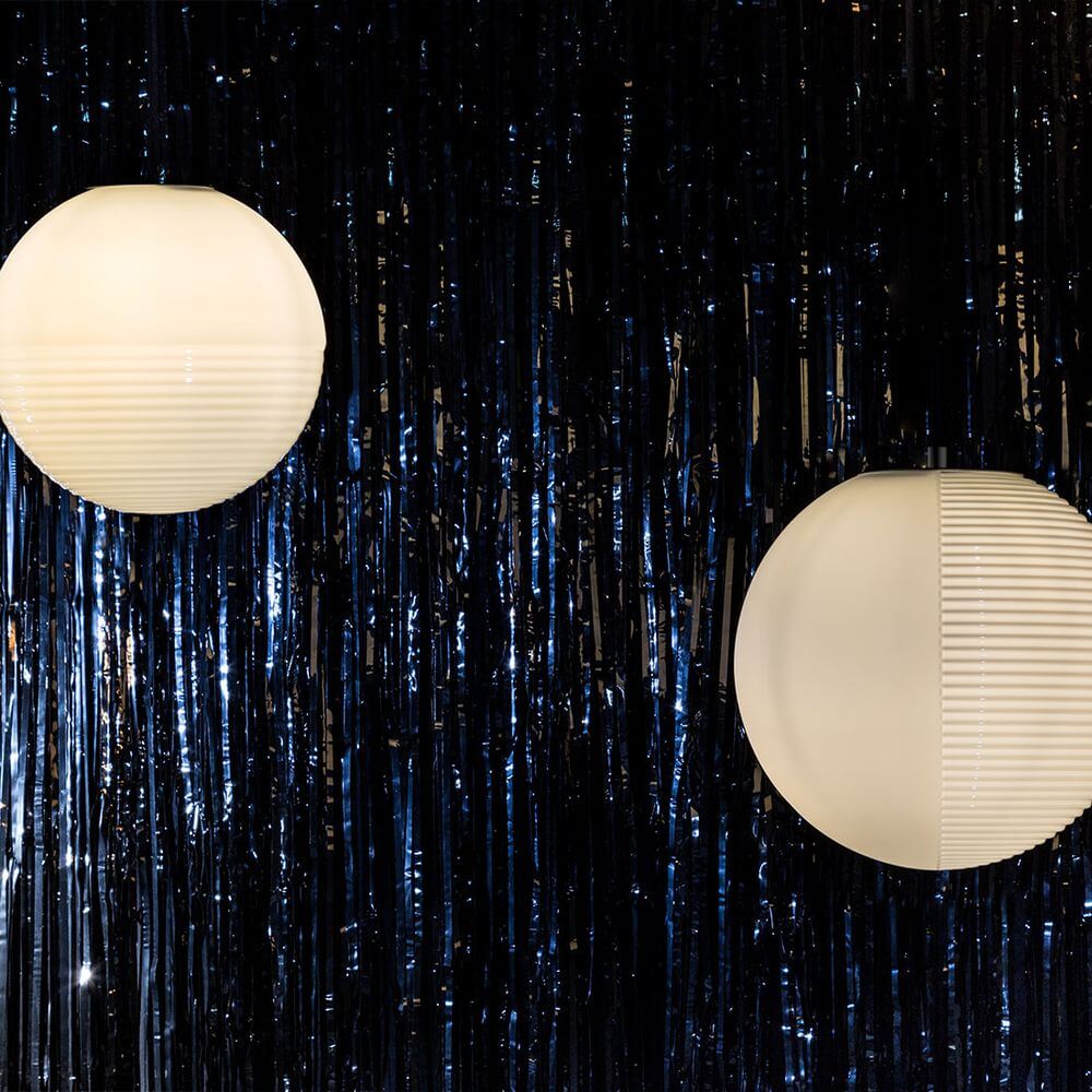 Pulpo LED Pendelleuchte Stellar Medium in einem stilvollen Raum mit schwarzem Hintergrund.