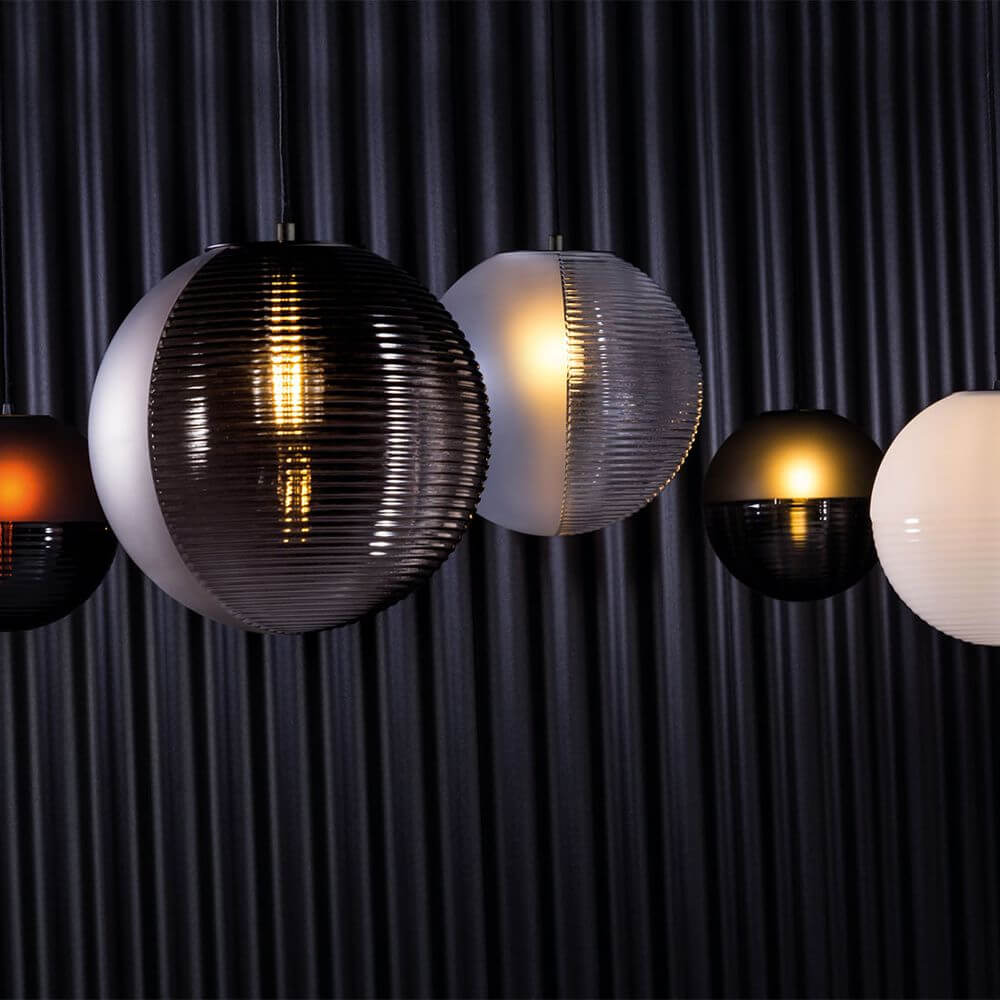 Pulpo LED Pendelleuchte Stellar Medium: Moderne, geformte Glaskugeln mit sanftem Licht auf schwarzem Hintergrund.