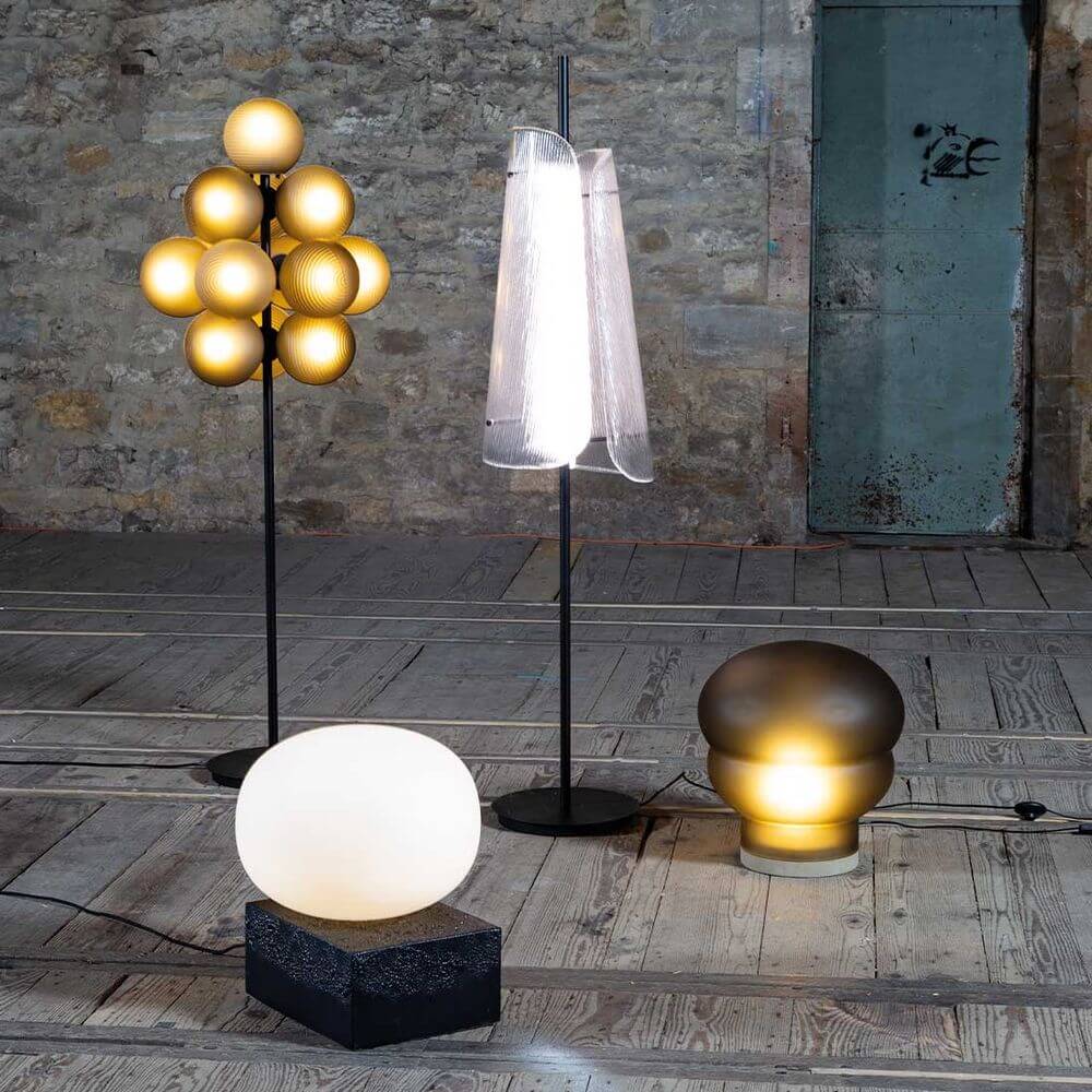 Verschiedene moderne Stehleuchten aus Glas in einem stilvollen Raum, einschließlich der Pulpo LED Stehleuchte Bent One.