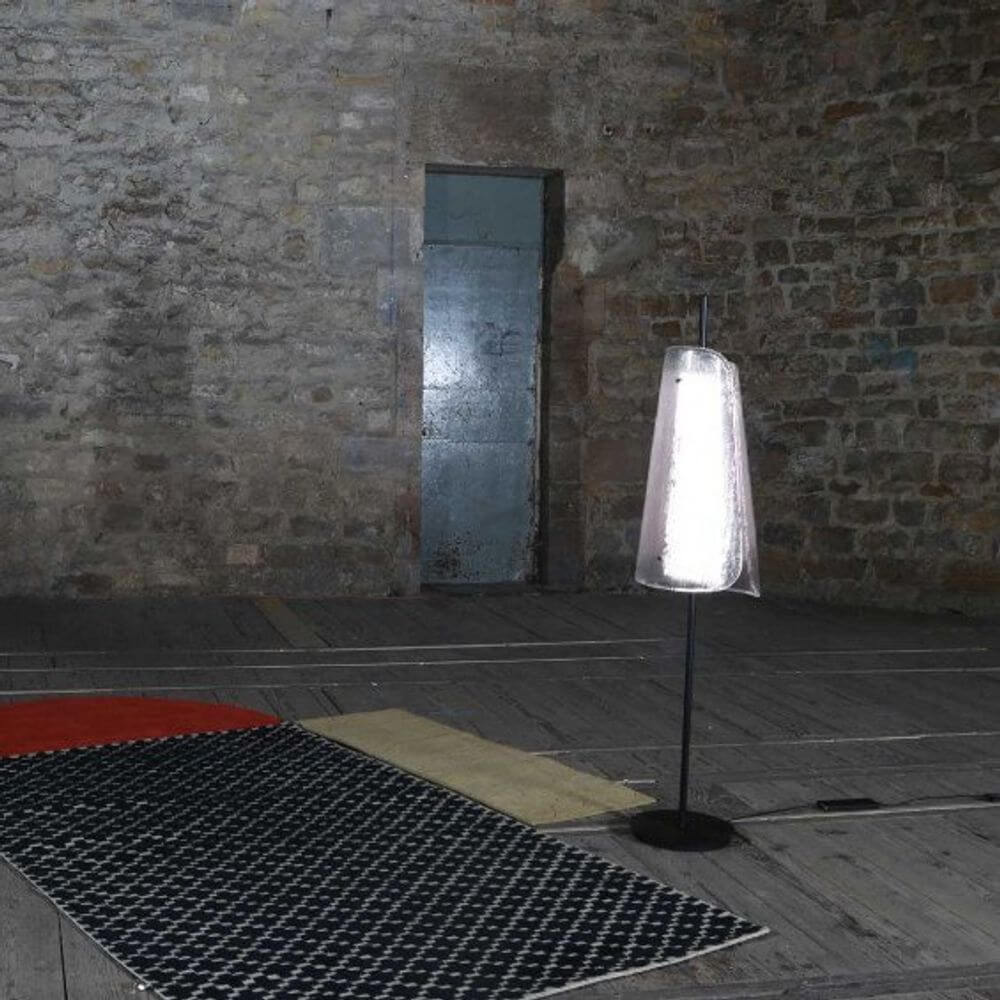 Pulpo LED Stehleuchte Bent One Glass in einer minimalistischen Umgebung, beleuchtet und dekorativ.