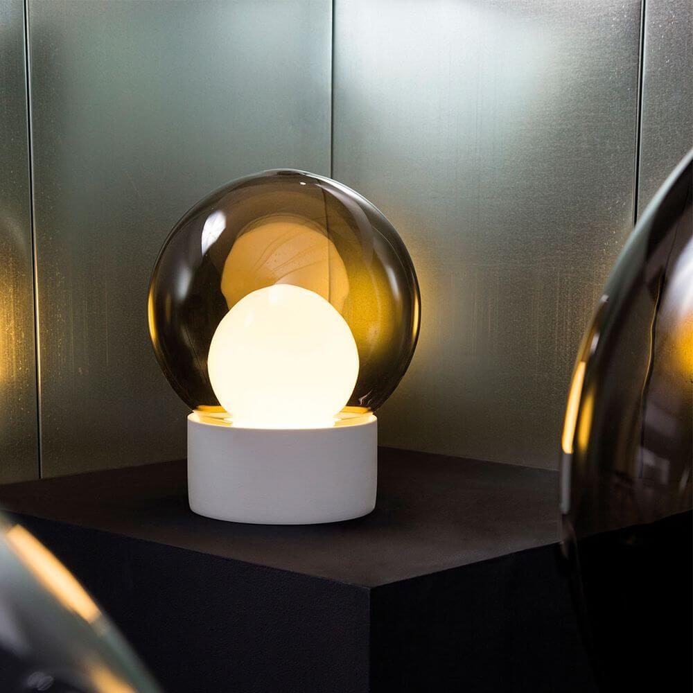 Stilvolle Pulpo Boule Tischleuchte mit mattiertem Porzellanfuß und mundgeblasenem Glas, ideal für indirekte Beleuchtung.
