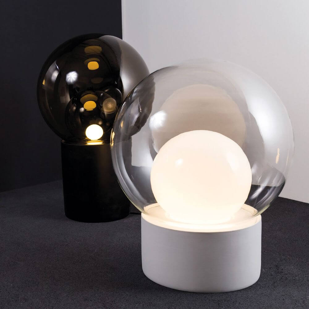 Pulpo Boule Tischleuchte in Schwarz und Transparent mit mattiertem Porzellanfuß und mundgeblasenem Kugelglas.