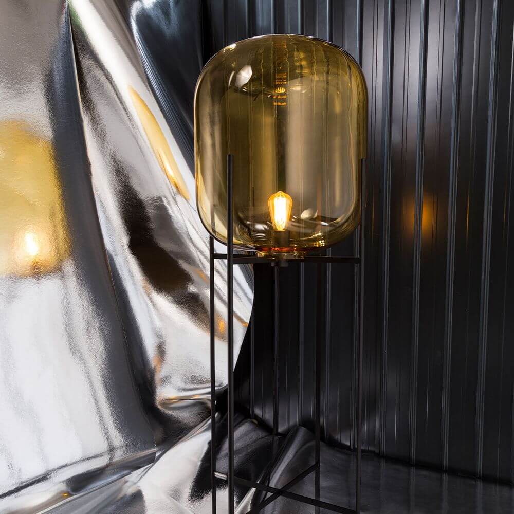 Pulpo LED Tischleuchte Oda Small mit mundgeblasenem Glas und schlanker Metallbasis, warmes Licht auf einem reflektierenden Hintergrund.