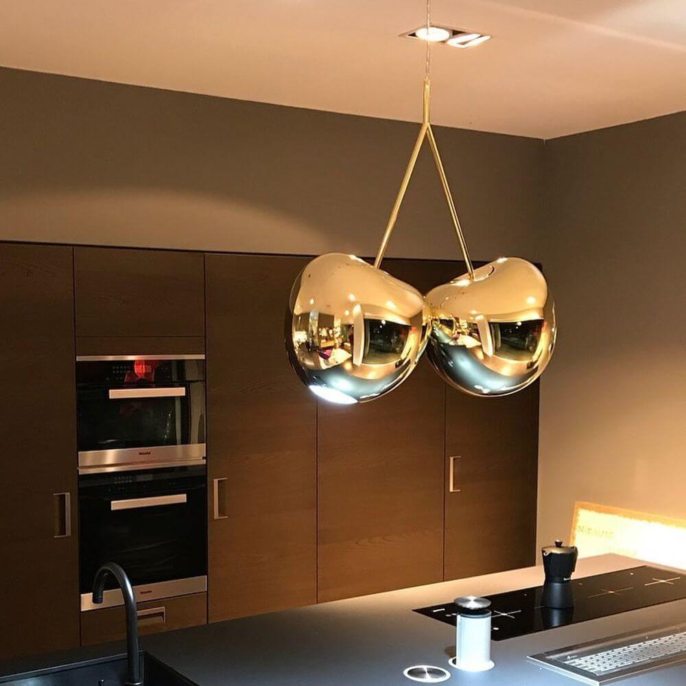 Cherry Lamp Metall Pendelleuchte Kirsche in goldener Ausführung über moderner Kücheninsel.