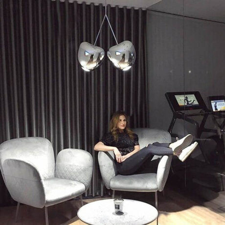 Cherry Lamp Metall Pendelleuchte Kirsche über modernen Sessel und Tisch in stilvollem Raum.
