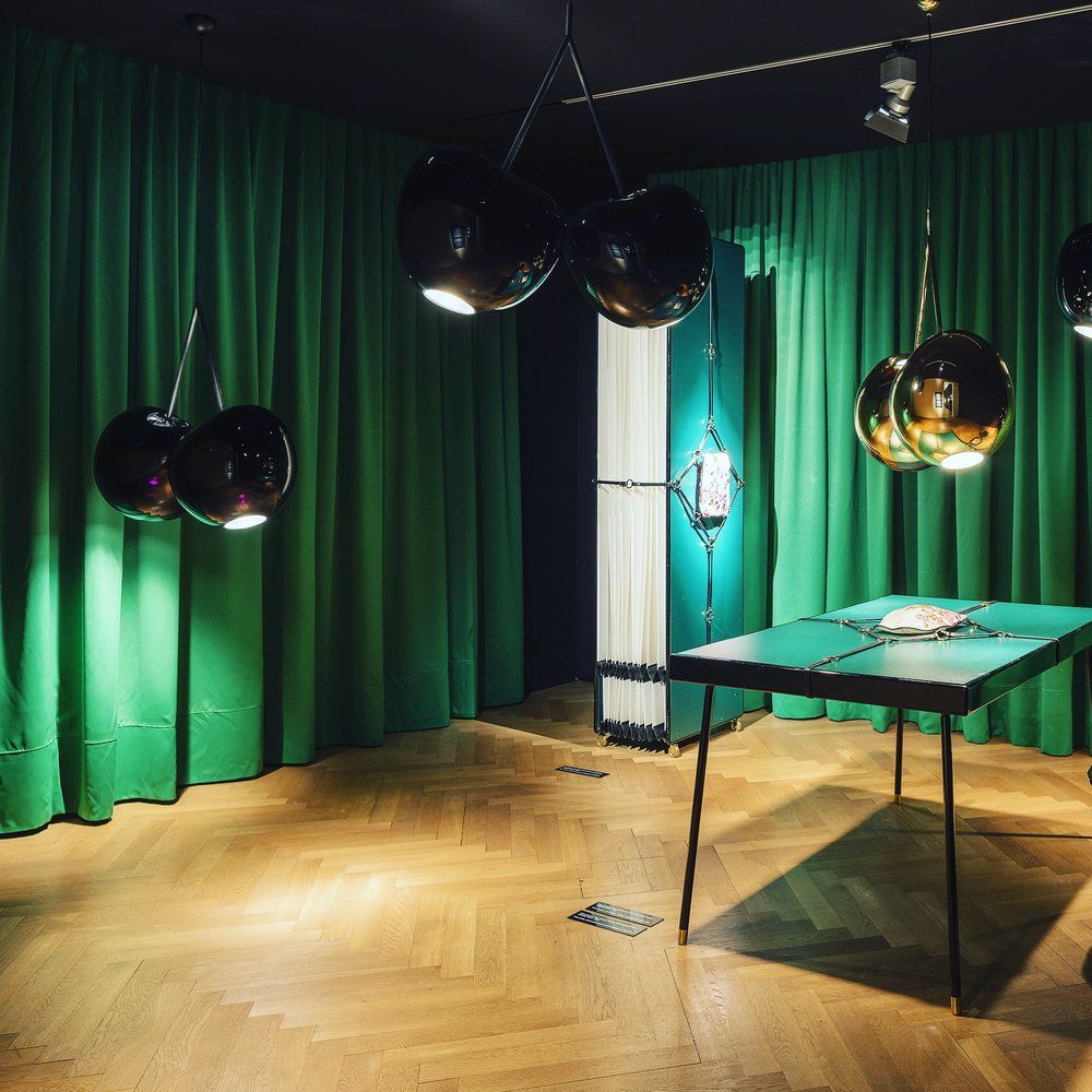 Cherry Lamp Pendelleuchte Kirsche in einem stilvollen Raum mit grünen Vorhängen und modernem Tischdesign.