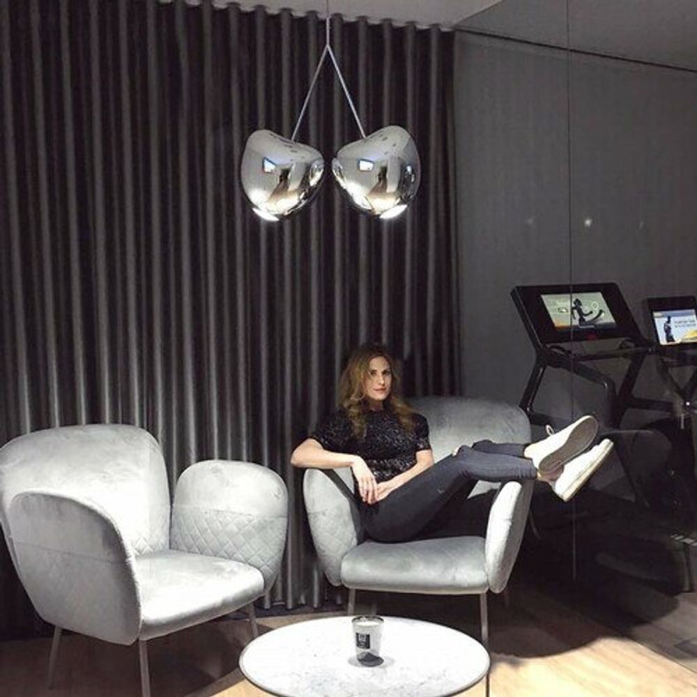 Cherry Lamp Pendelleuchte Kirsche in modernem Wohnzimmer mit stilvollen Sesseln und Frauen. Elegantes Design.