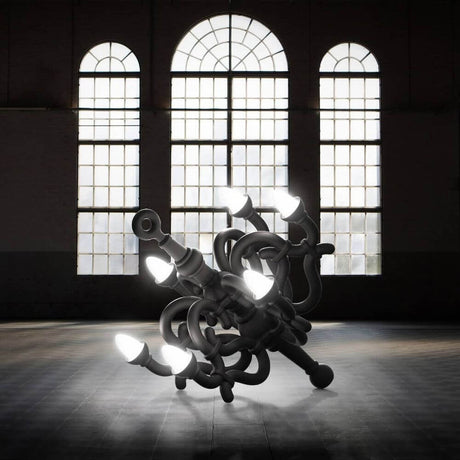 Fallen Chandelier M Akku Bodenleuchte im Innenraum mit großen Fenstern und futuristischem Design.