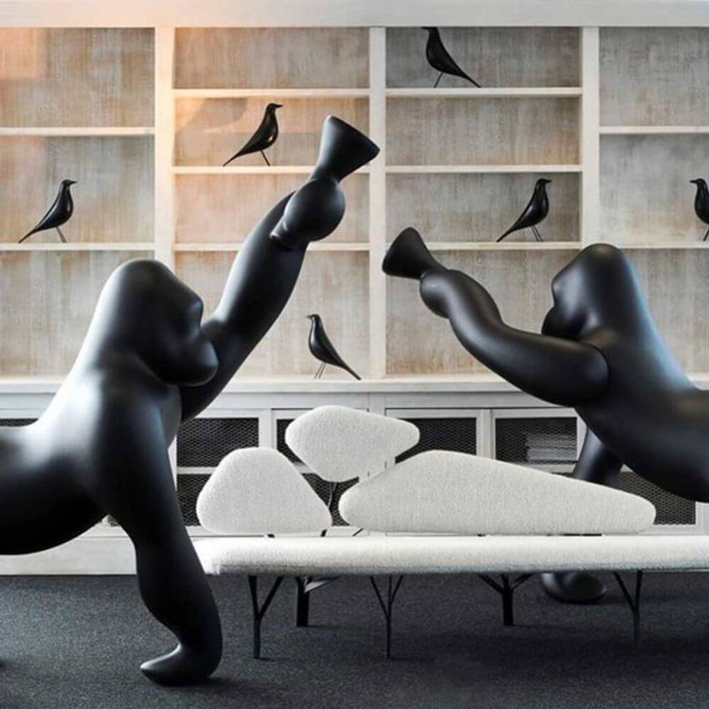 Zwei schwarze Gorillas in einem modernen Wohnzimmer, die Kong XL Bodenleuchte Gorilla kreativ simulieren.