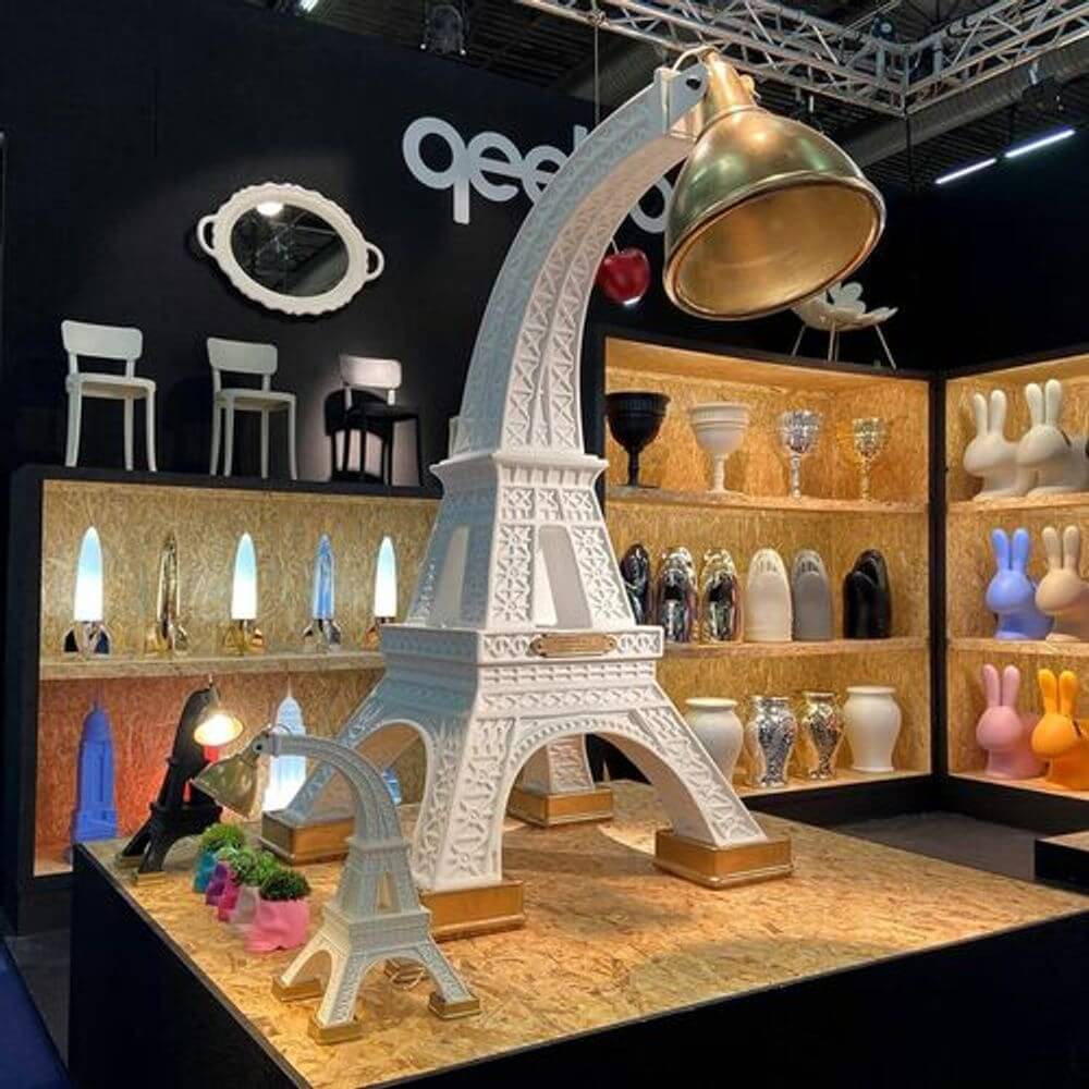 Paris XL Stehleuchte Eifelturm 225cm in einem modernen Ausstellungsraum, umgeben von dekorativen Objekten.
