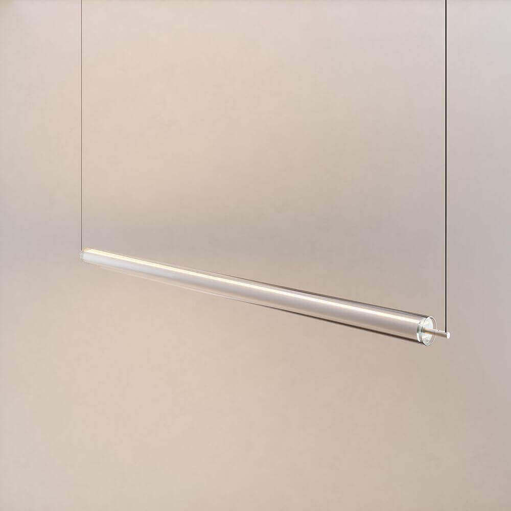 Transparente hängende Lampe mit minimalistischer Metallaufhängung vor neutralem Hintergrund.