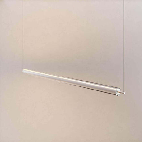 Transparente hängende Lampe mit minimalistischer Metallaufhängung vor neutralem Hintergrund.