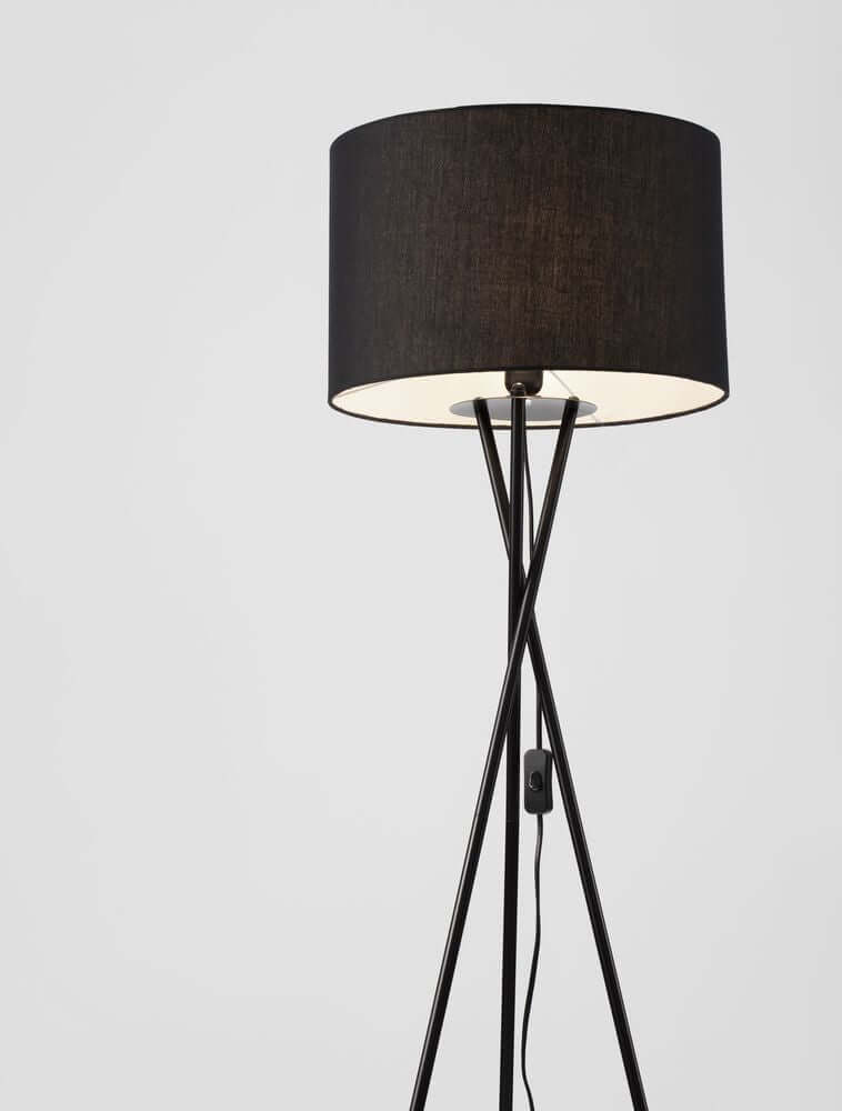 Retro Stehlampe Schwarz mit schwarzem Textilschirm und filigranem Dreibein-Gestell aus Metall.