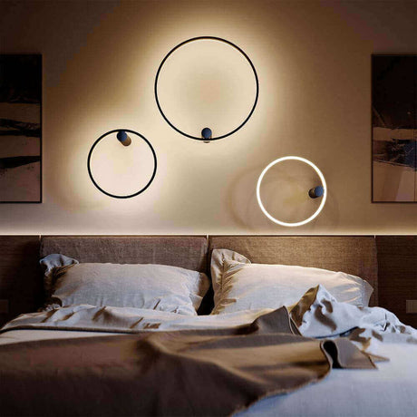 Moderne Wandlampen in drei kreisförmigen Designs, die einen Schlafbereich stilvoll beleuchten.