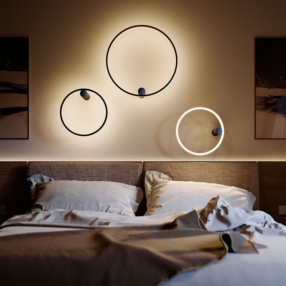 Moderne Wandleuchten in Kreisform über einem stilvollen Bett, erzeugen ein sanftes Ambiente im Schlafzimmer.