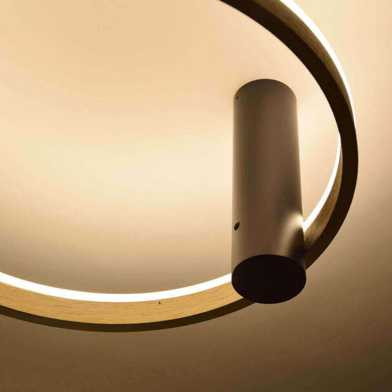 Modern ceiling light with a round wooden frame and an elegant matte black cylinder.