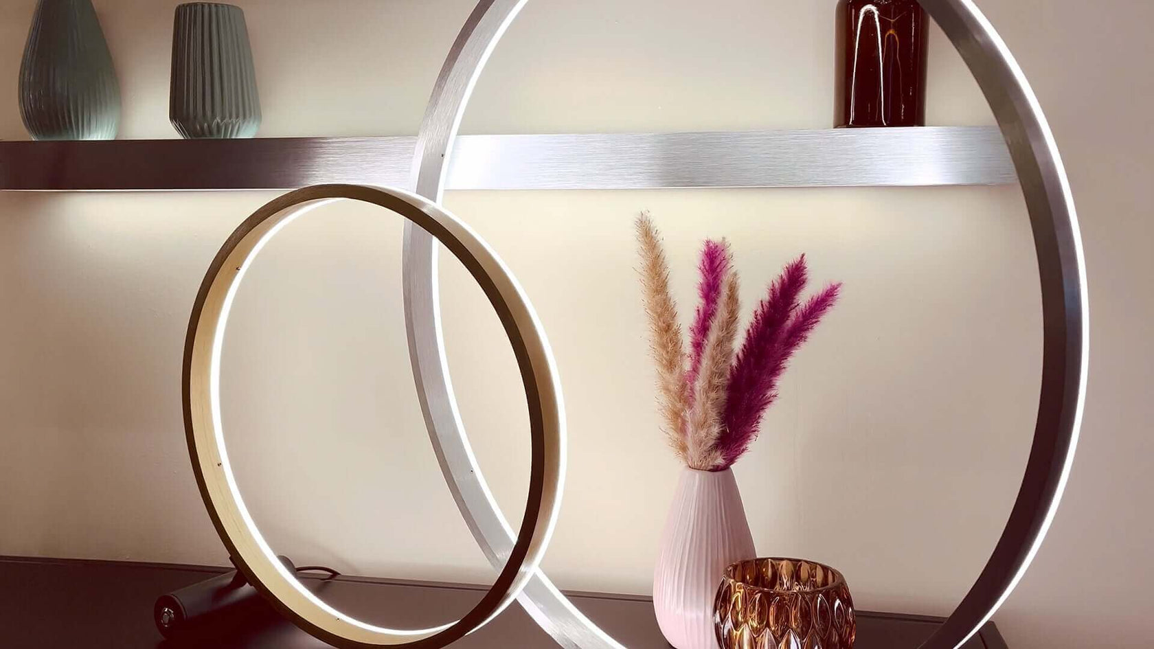 Moderne Leuchten und dekorative Glasvase mit Trockenblumen in stilvollem Innenraum.