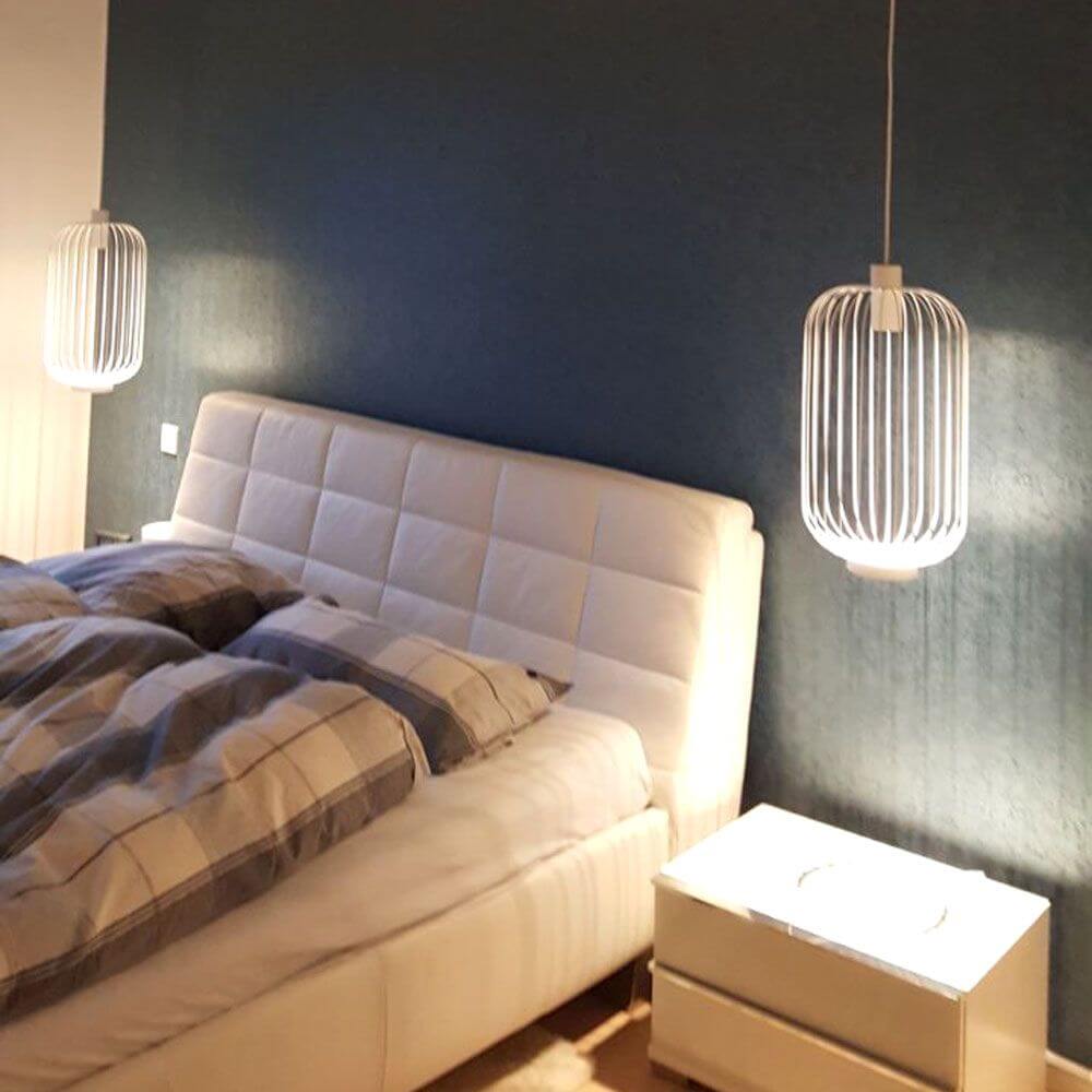 Moderne Pendelleuchten s.luce Rooms über einem Bett in stilvollem Schlafzimmer mit warmem Licht.
