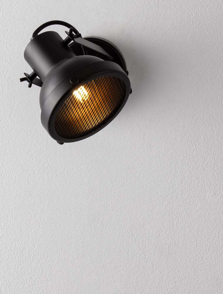 Ruvi Wandleuchte Schwarz mit modernem Industrial-Design, mattschwarzem Metall und kontrastreichem Licht.