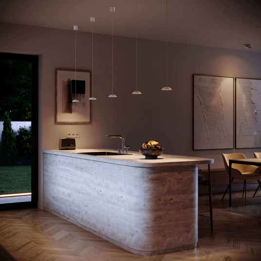 Moderne Küche mit elegantem Betoninsel, sanfter Beleuchtung und stilvoller Einrichtung bei Nacht.