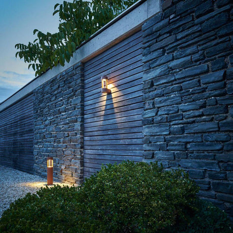 SLOTS WALL Wandleuchte rostfarben 6,3W LED Warmweiß an einer Steinmauer im Außenbereich