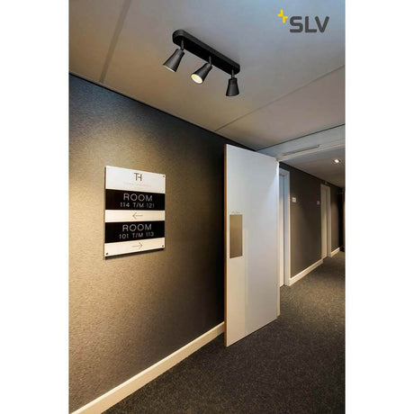 Avo Triple surface-mounted light in black in a modern hallway with room number signs