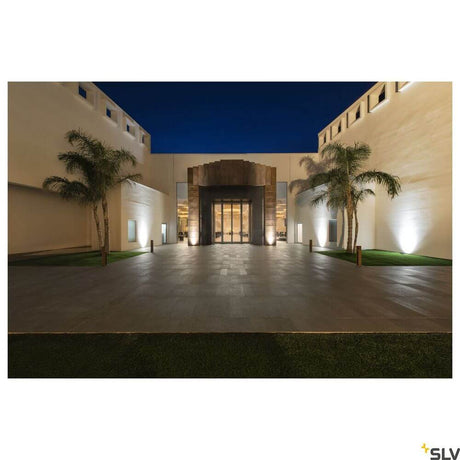 Dasar 270 4000K round symmetrical IP67 outdoor lighting with a modern design and a palm-lined entrance.