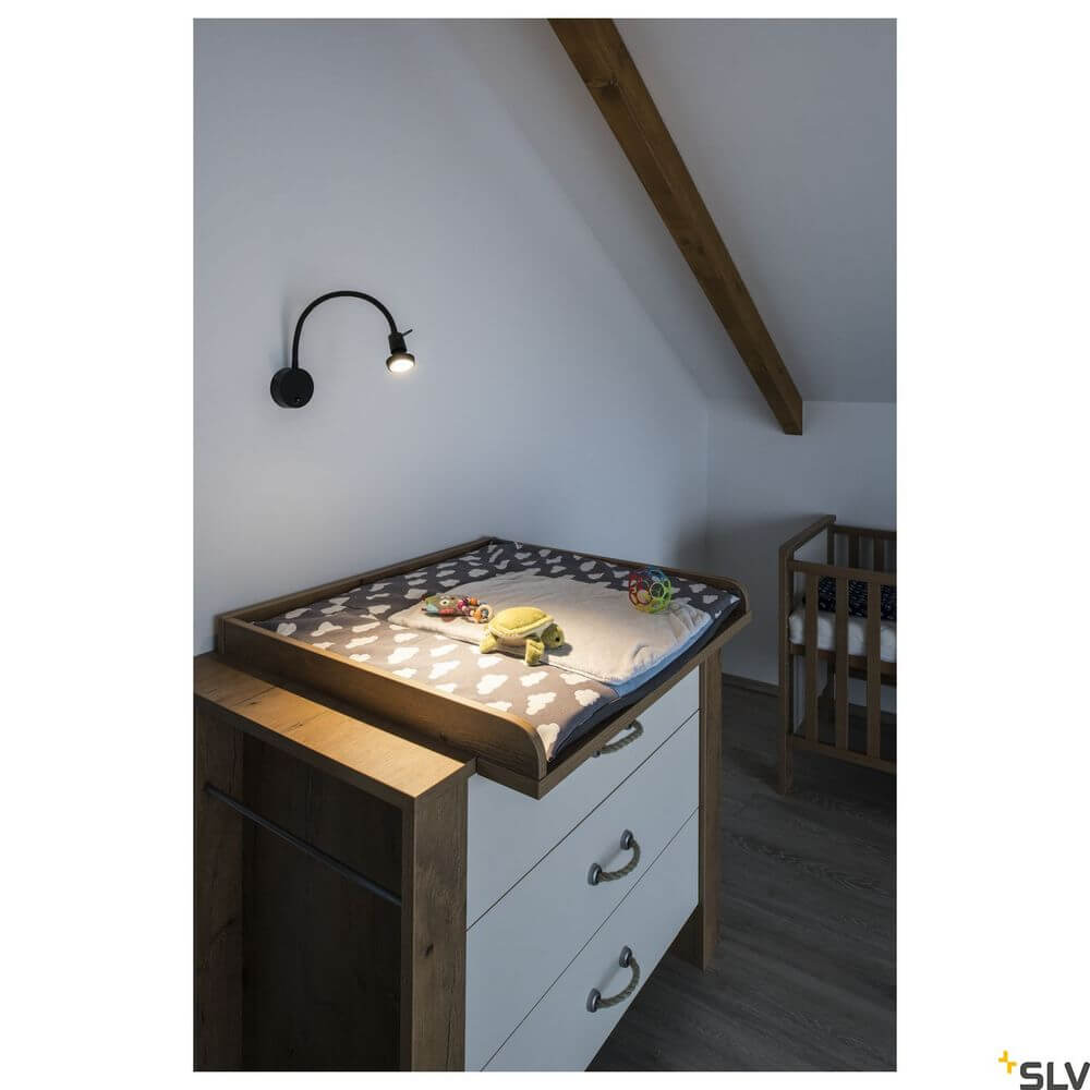Dio Flex Plate QPAR51 Wandlampe Schwarz über Wickeltisch in modernem Kinderzimmer.