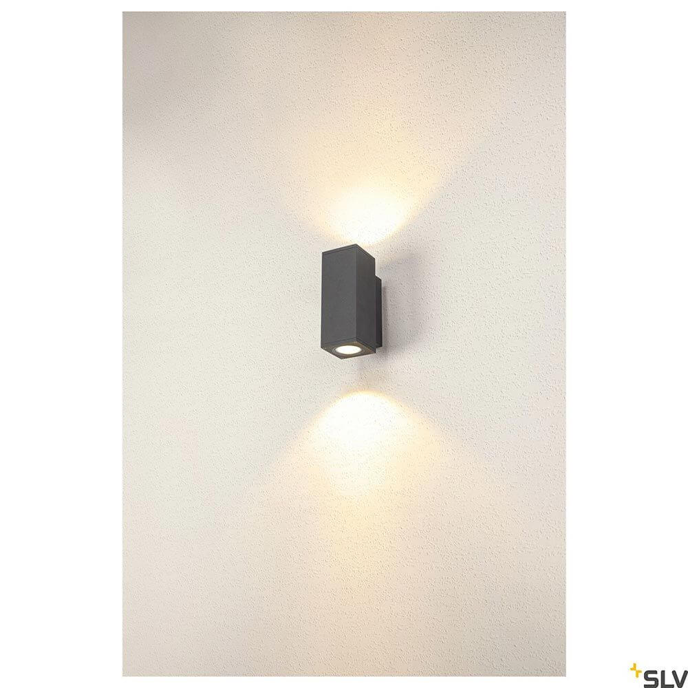Enola LED Wandaufbauleuchte CCT Up&Down Outdoor auf einer Wand montiert, Licht strahlt nach oben und unten.