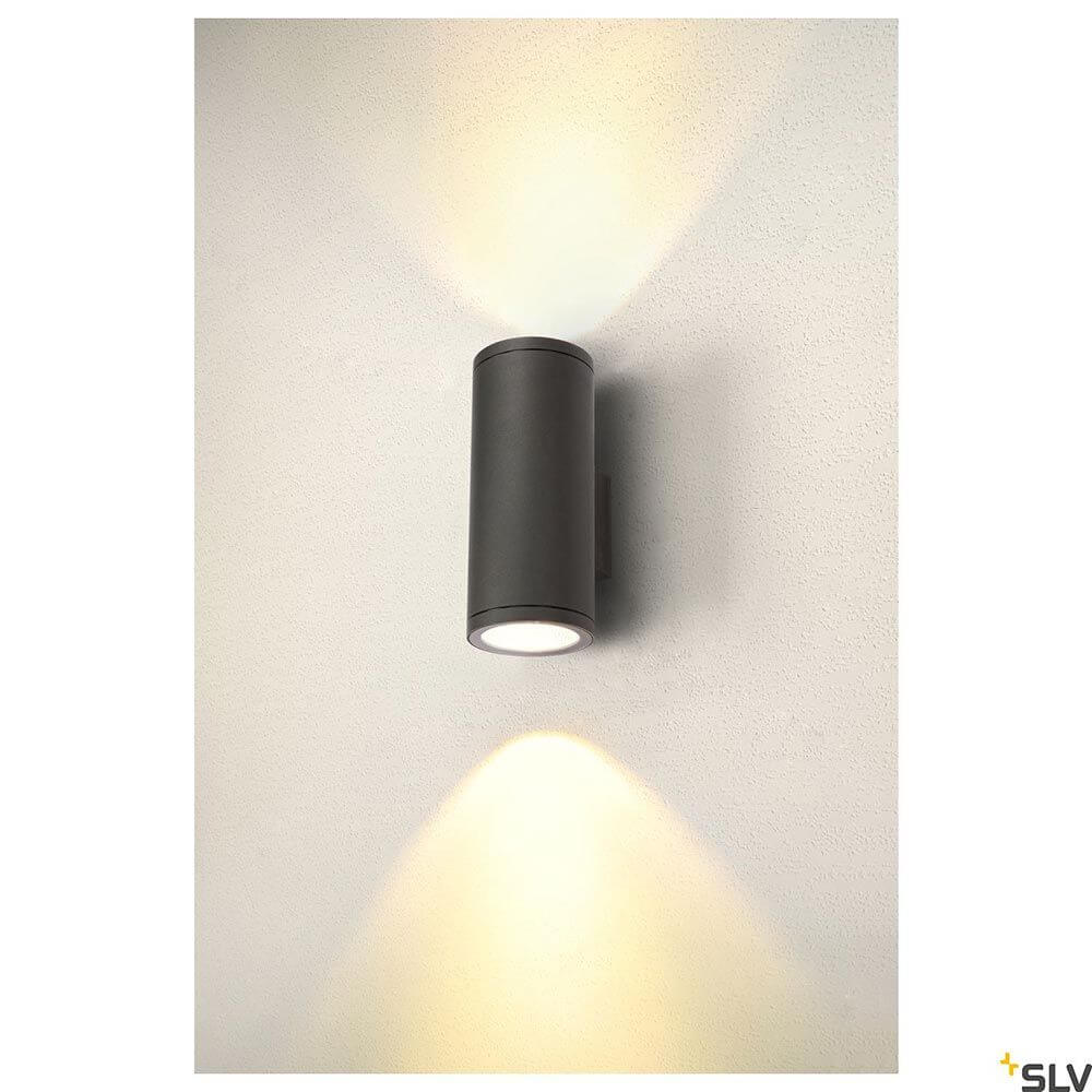 Enola Round Up&Down Outdoor LED Wandaufbauleuchte 2-flammig CCT an einer Wand montiert, mit warmem Licht und modernem Design.