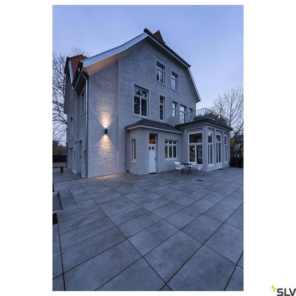 Enola Round Up&Down Outdoor LED Wandaufbauleuchte 2-flammig CCT an moderner Hausfassade bei Dämmerung.