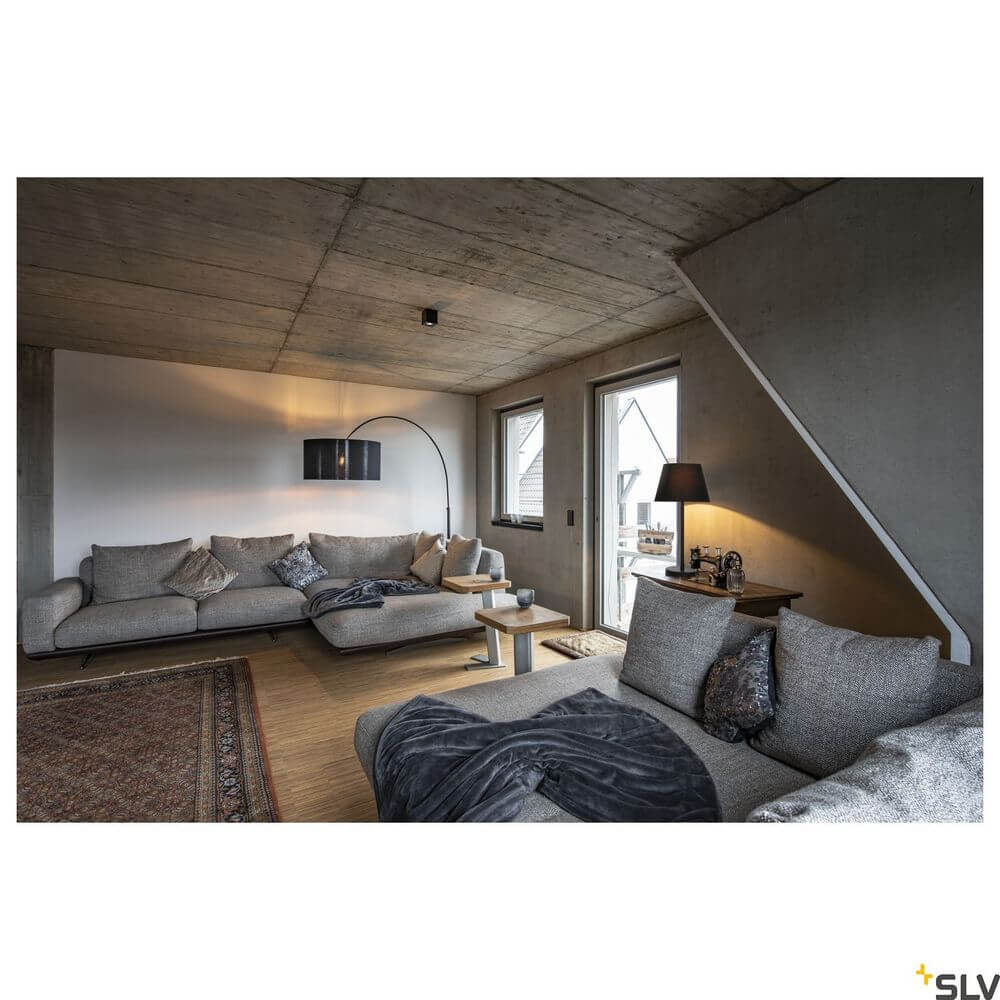 Fenda Bow Basis E27 Bogenleuchte Schwarz (ohne Schirm) über Sofa in modernem Wohnzimmer, gebogener Arm und massive Bodenplatte sichtbar