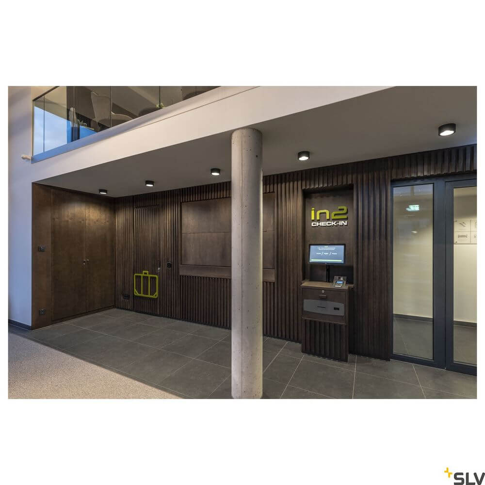 Moderner Empfangsbereich mit Holzvertäfelung und LED-Beleuchtung, ideal für Check-in Services.