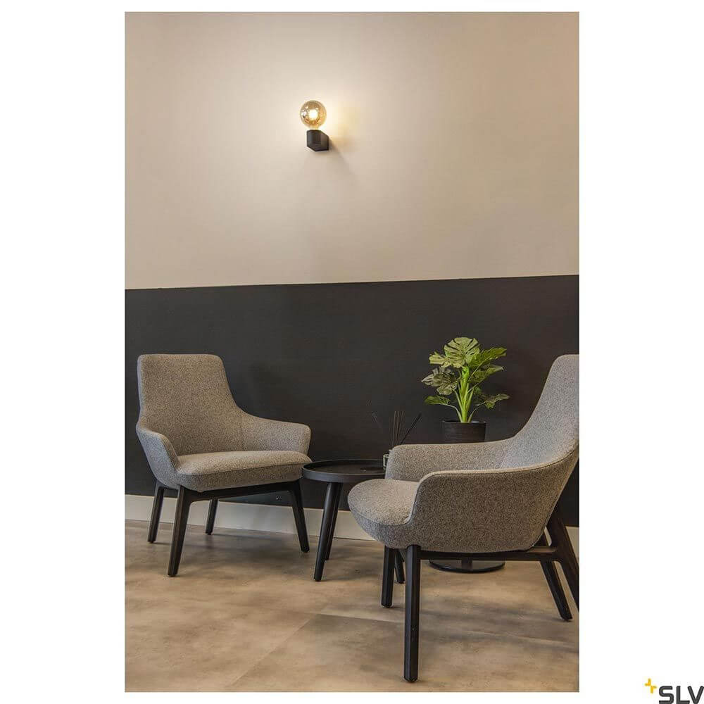 Fitu Cube Wandleuchte in modernem Ambiente mit grauen Stühlen und stilvollem Tisch.