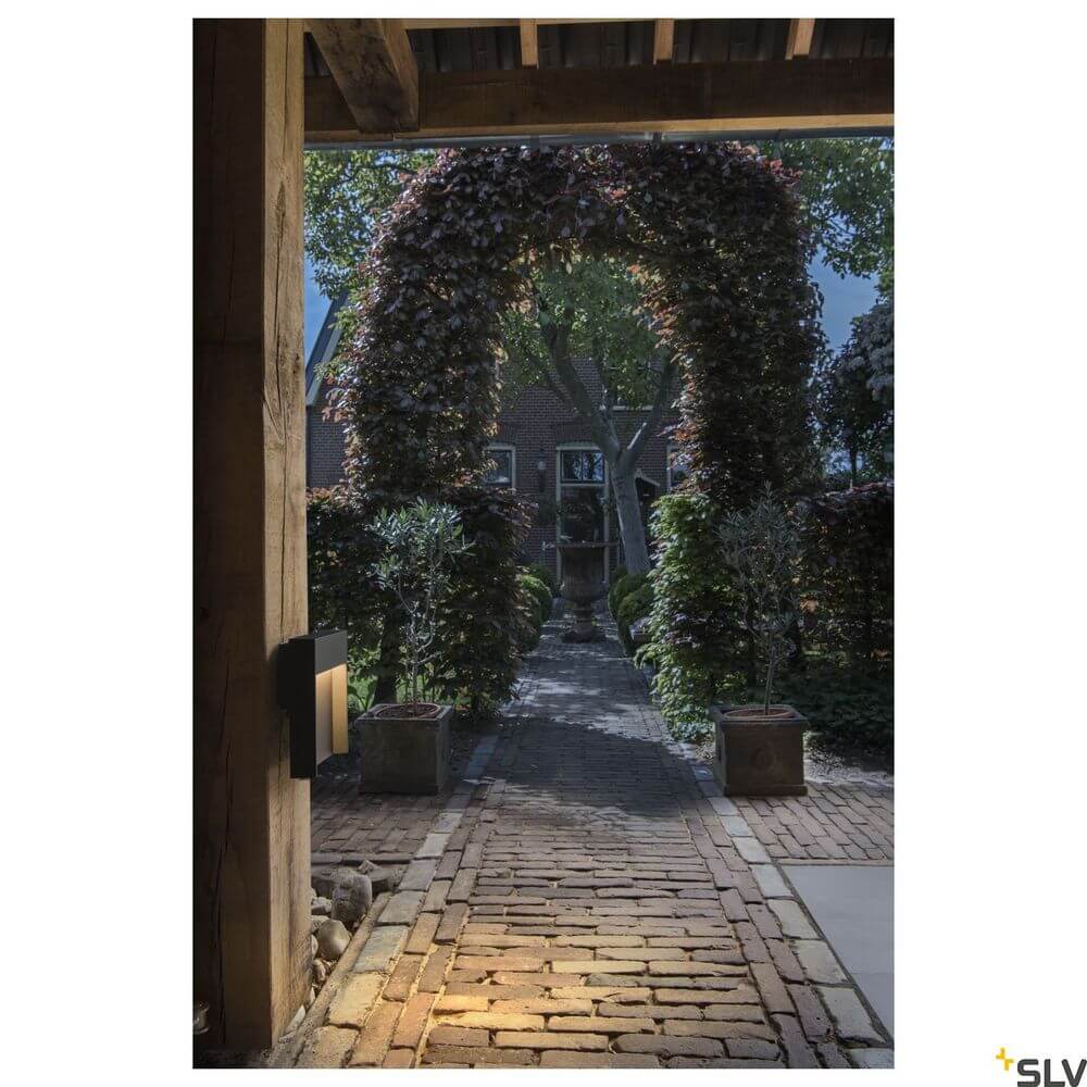 Flatt Outdoor LED Wandlampe 3000K IP65 Anthrazit an einem modernen Gartenweg bei Nacht.