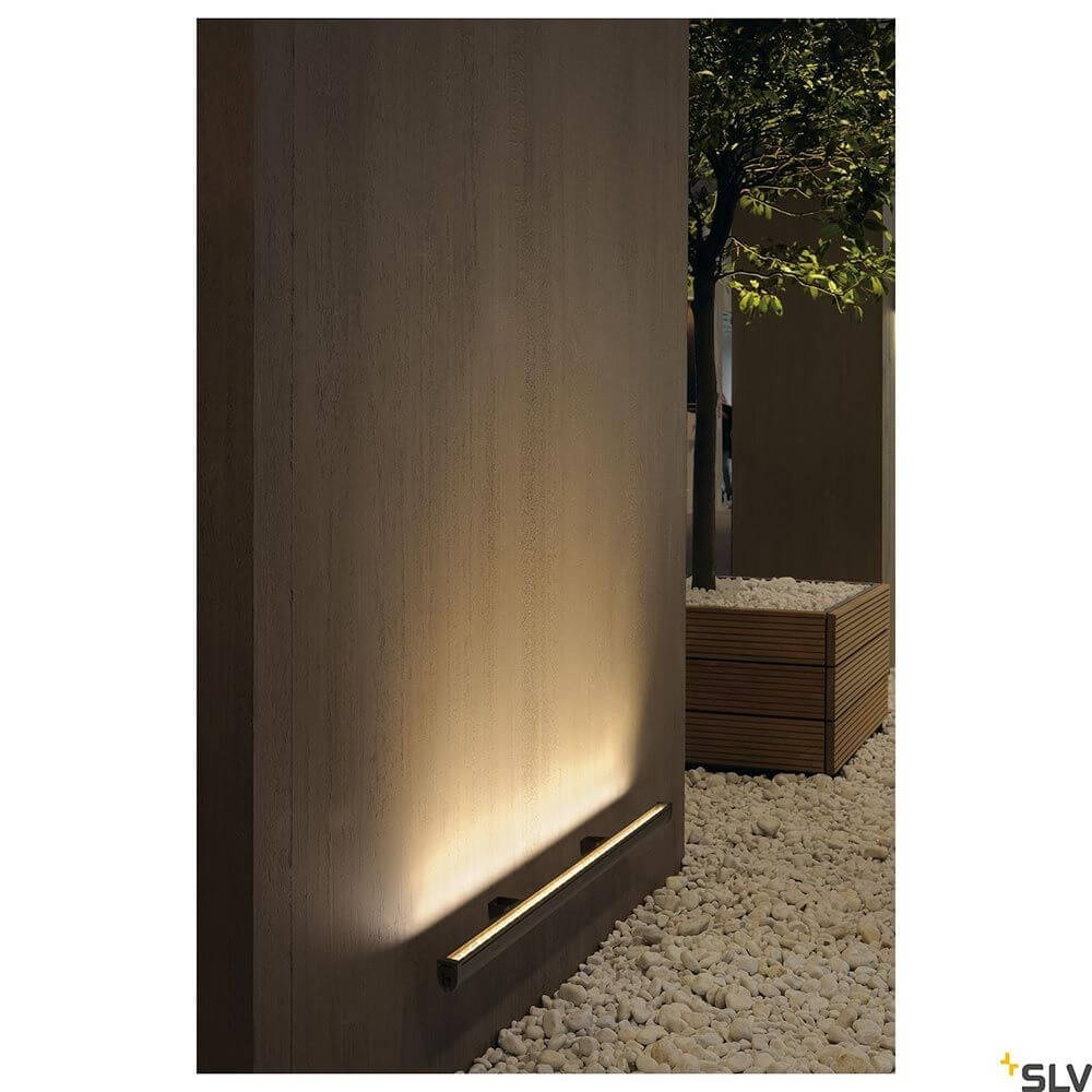 Wandleuchte Galen LED Profil in Outdoor-Einstellung, weich beleuchtete Wand mit Holz- und Steinelementen.