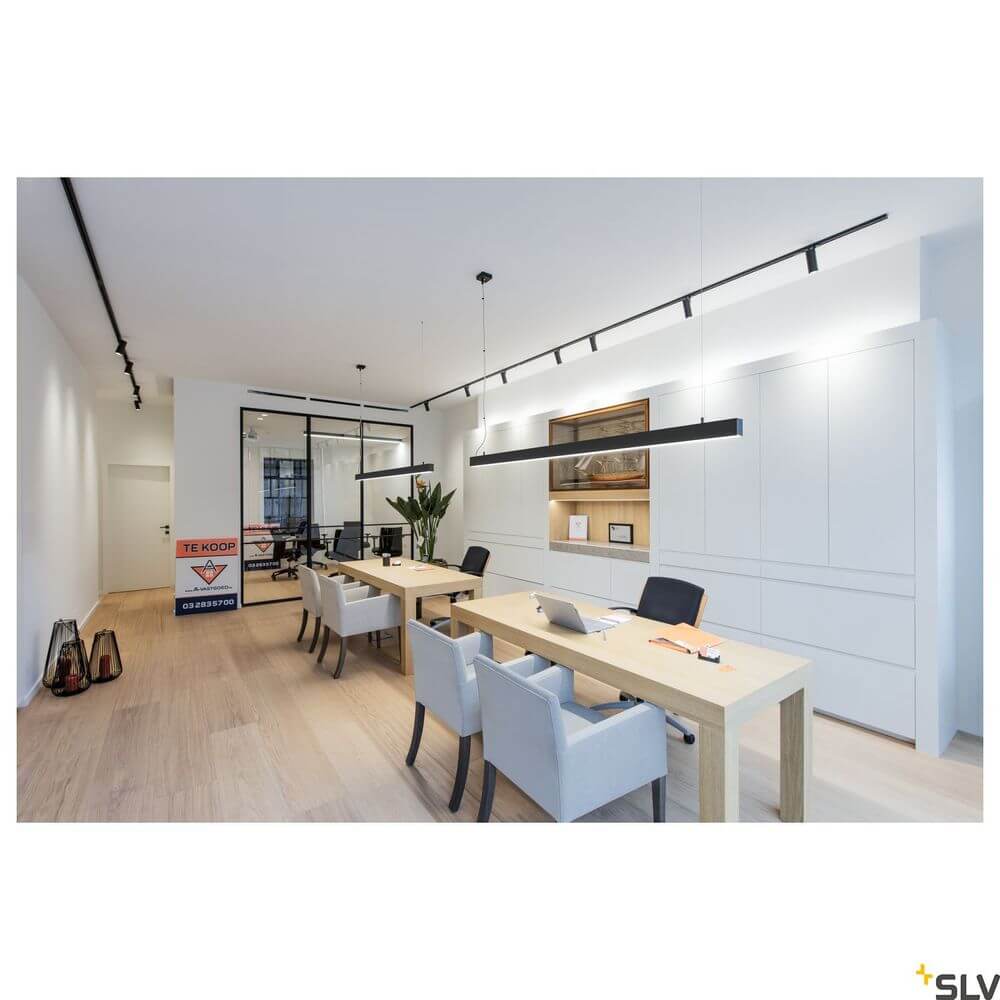 Moderne Büroumgebung mit Glenos 2m Pendellampe in Schwarz an einem langen Tisch, helles Licht, elegantes Design.